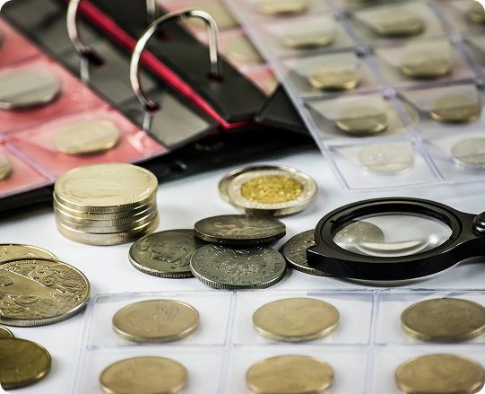 A collection of coins and a binder on top of a table.