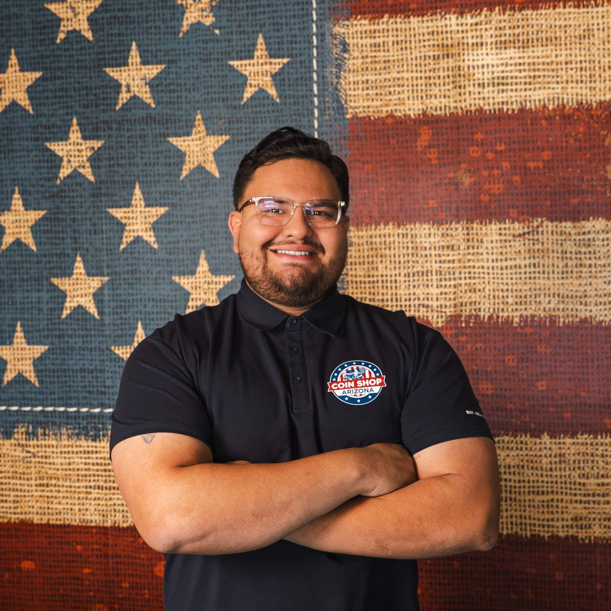 Man with crossed arms and flag backdrop